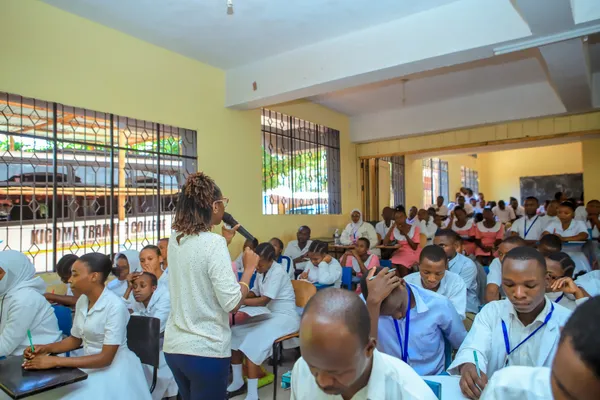 Presenter speaking to a packed hall at Kigoma Training College, WSCD 2026